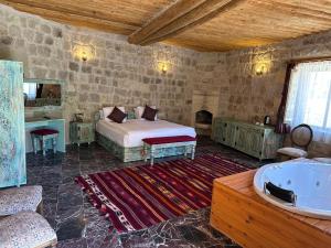 um quarto com uma cama e uma banheira num quarto em Doctor's Cave Cappadocia em Ürgüp