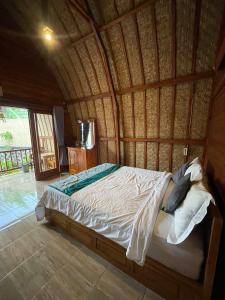 - une chambre avec un lit dans une pièce en bambou dans l'établissement Kintamani Blessing, à Kubupenlokan