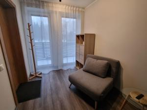 a living room with a chair and a window at J55 Apartments in Rīga