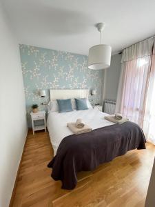 a bedroom with a large white bed with blue walls at Apartamento en el centro de Benasque in Benasque