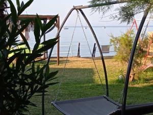 a swing in a yard with the ocean in the background at Kefalonia Beach Hotel & Bungalows in Lixouri