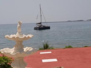a boat in the water with a fountain with a sailboat at Kefalonia Beach Hotel & Bungalows in Lixouri