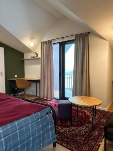 1 dormitorio con cama, mesa y ventana en HERBS & HONEY boutique hotel & restaurant, 