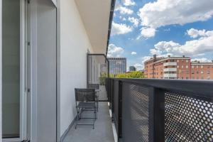 balcón con sillas y vistas a la ciudad en BO 40 SELF CHECK-IN - Appartamento Fiera-Tecnopolo en Bolonia