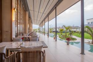 a restaurant with tables and chairs and a view of the ocean at Argyle Grand Hotel Nairobi Airport in Nairobi