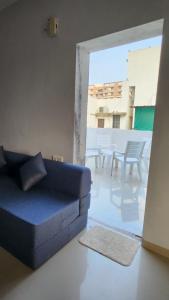 ガンディーナガルにあるVIAAN Penthouse 1 BHK with terraceのリビングルーム(青いソファ、パティオ付)