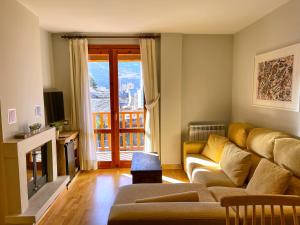 a living room with a couch and a fireplace at Apartamento en el centro de Benasque con piscina in Benasque