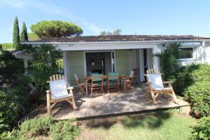 a deck with a table and chairs on it at GASMED29 - Golfe de St-Tropez - Chalet californien dans domaine privé in Gassin