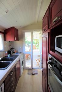 a kitchen with a sink and a microwave at GASMED29 - Golfe de St-Tropez - Chalet californien dans domaine privé in Gassin