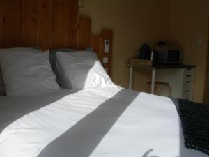 1 dormitorio con 1 cama con sábanas blancas en Chambre nature en Arès