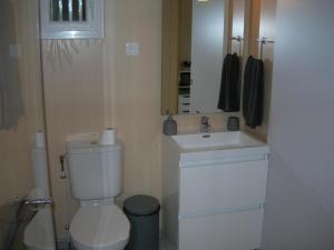 a bathroom with a white toilet and a sink at Chambre nature in Arès