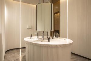 a bathroom with a sink and a mirror at Argyle Grand Hotel Nairobi Airport in Nairobi