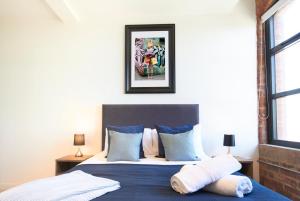 1 dormitorio con 1 cama con sábanas y almohadas azules en Sleek New York style Apartment in Central Leeds, en Leeds