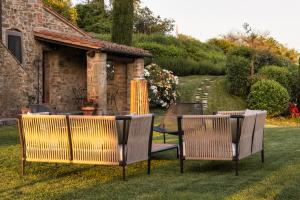 three chairs and a table in a yard at Mulino a Vento in Cortona