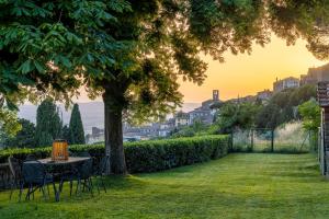 a table and chairs under a tree in a yard at Mulino a Vento in Cortona