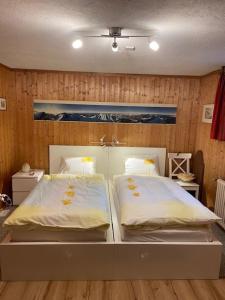 - 2 lits dans une chambre dotée de murs en bois dans l'établissement Sansoucis, à Tegna