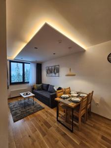 uma sala de estar com uma mesa e um sofá em Apart Hotel Zlatni Javor, Apartment 410 em Jahorina