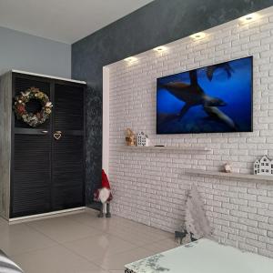 a living room with a tv on a brick wall at Apartment on Tytova 8 in Dnipro +7 photos