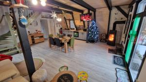 a living room with a christmas tree and a table at Porumbacu Retreat-Cabana Forest A-frame și Chalet Max cu jacuzzi și piscină sezonieră, pe malul râului ,în apropiere de Transfăgărășan, Sibiu in Porumbacu de Sus