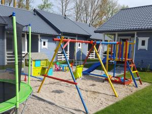 a playground with colorful play equipment in a yard at Comfortable holiday home for 4 people Ustronie Morskie in Ustronie Morskie