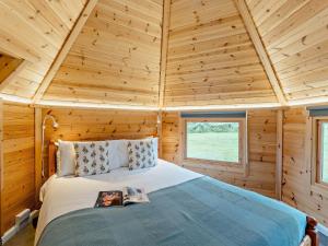 a bedroom with a bed in a wooden cabin at 1 Bed in Biggar 91250 in Libberton