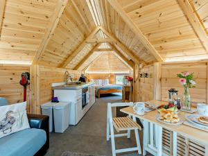 a kitchen and living room of a wooden cabin at 1 Bed in Biggar 91250 in Libberton