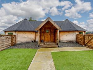 a cabin with a wooden door and a fence at 1 Bed in Biggar 91252 in Libberton
