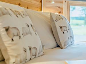 a group of pillows with sheep on a bed at 1 Bed in Biggar 91252 in Libberton