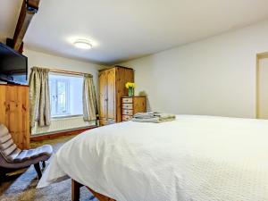 a bedroom with a large white bed and a chair at 3 Bed in Shap 91262 in Shap