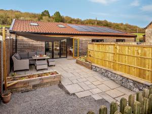 een patio met een bank, een tafel en een hek bij 2 Bed in Cheddar 91358 in Loxton