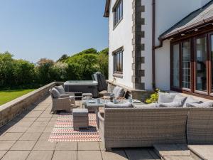 une terrasse avec des canapés, une table et une télévision dans l'établissement 6 Bed in Clovelly 1.5mls S 91361, à Clovelly