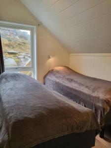2 letti in una camera con finestra di Spektakulær rorbu i autentiske omgivelser a Ballstad