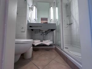 a bathroom with a sink and a toilet and a shower at Apartment-Hotel Hamburg Mitte in Hamburg