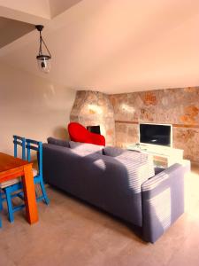 a living room with a gray couch and a red chair at Spectacular Penthouse with Terrace near Hadrian's Gate in Antalya