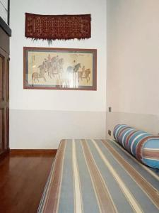 ein Zimmer mit einem Gemälde an der Wand und einem Bett in der Unterkunft Casa Gastone in Rimini