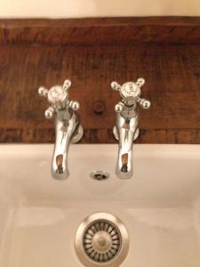 zwei Metallhähne auf einem weißen Waschbecken in der Unterkunft Casa Gastone in Rimini