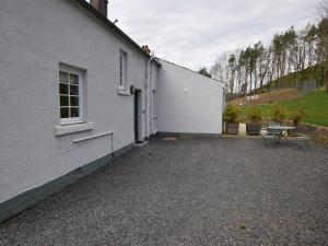 a white house with a patio next to a building at 2 Bed in Lauder 91383 in Lauder