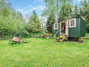 a green tiny house in a yard with a swing at 1 Bed in Coleford 91373 in Bream
