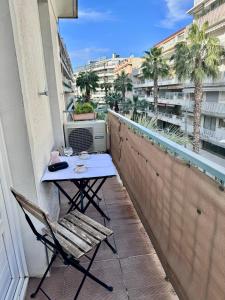 een tafel en stoelen op een balkon met uitzicht bij Appartement Des Iles in Juan-les-Pins