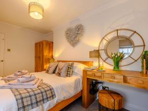 a bedroom with a bed and a desk with a mirror at 2 Bed in Alnwick 91316 in Alnwick