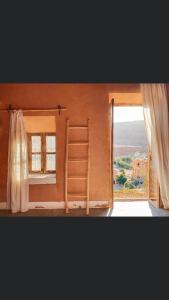 Habitación con cama y ventana con escalera en Tigmi Hamid en Aït Ben Haddou