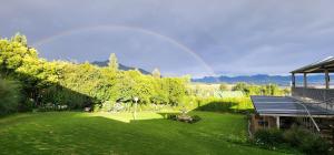 Blick auf einen Garten mit Regenbogen im Hintergrund in der Unterkunft Ash River Lodge in Clarens