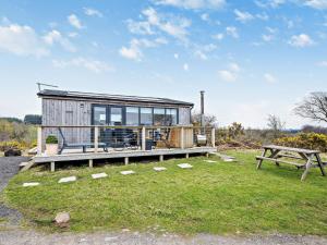 a tiny house with a picnic table and a bench at 1 Bed in Dalry 91418 in Dalry