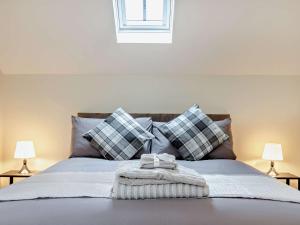 a bed with pillows and a blanket and two lamps at 1 Bed in Peak District 91367 in Youlgreave