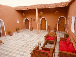 un patio al aire libre con sillas y mesas en un edificio en Tigmi Hamid, en Aït Ben Haddou