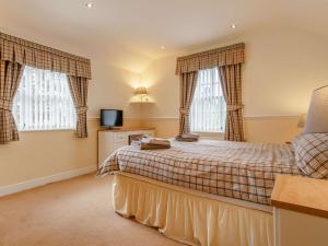 a bedroom with a bed and two windows at 1 Bed in Osmotherley 91336 in Osmotherley