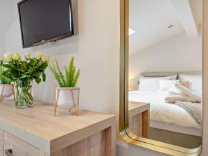 1 dormitorio con cama y espejo en 3 Bed in Pateley Bridge 91269 en Summer Bridge