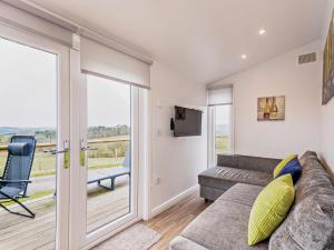 ein Wohnzimmer mit einem Sofa und einer Glasschiebetür in der Unterkunft 1 Bed in Dalry 91417 in Dalry