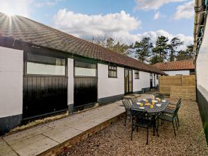 a patio with a table and chairs in front of a house at 3 Bed in Mattersey 91307 in Mattersey