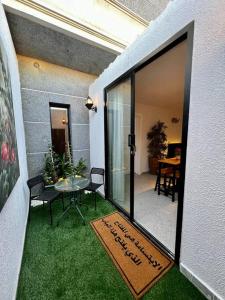 a door to a patio with a table and grass at Onyx residence in Riyadh
